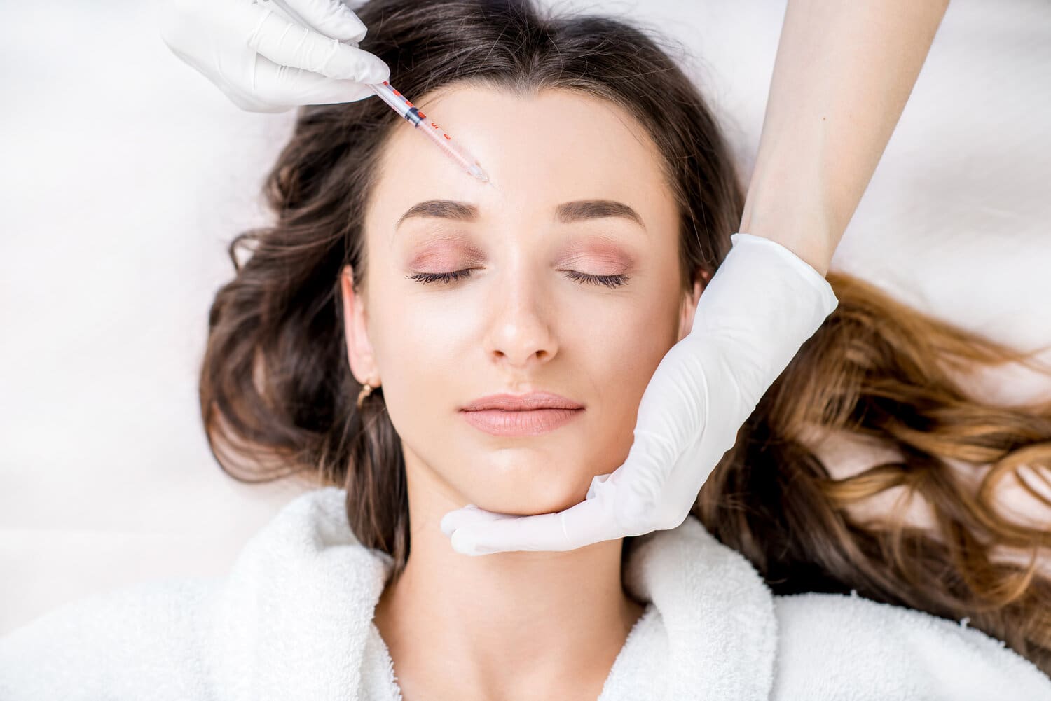 Woman,Receiving,A,Botox,Injection,In,The,Eye,Zone,Lying
