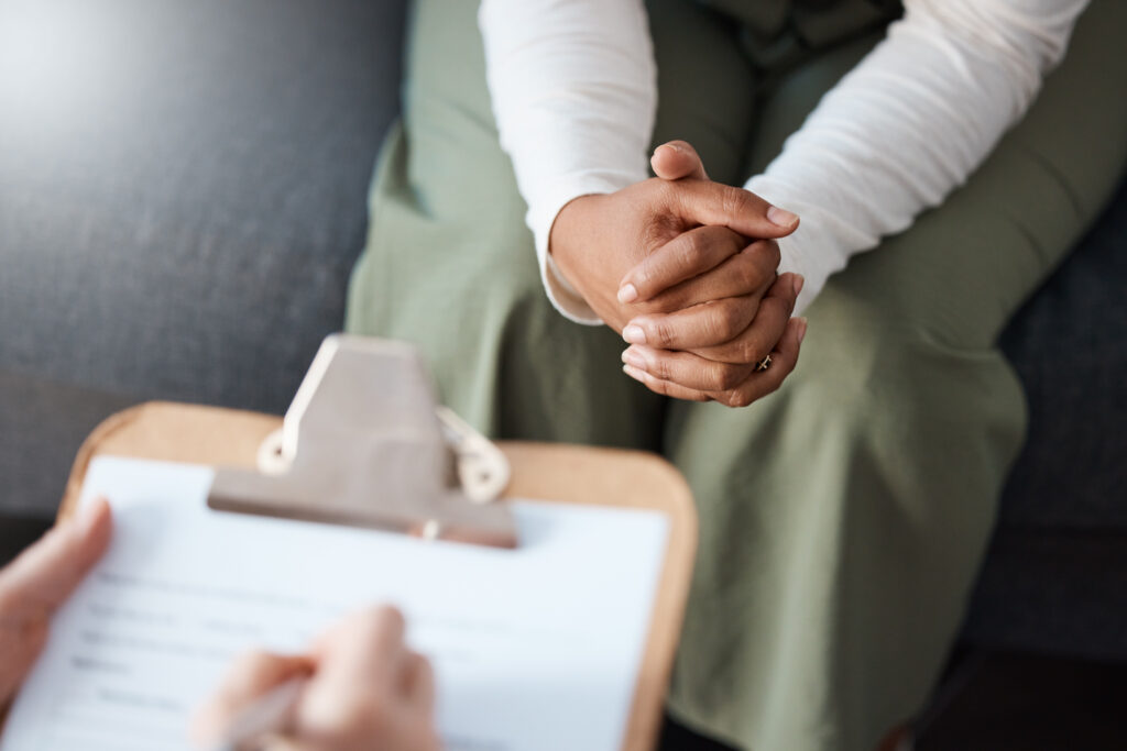 Woman, Hands And Therapist Writing On Clipboard In Consultation For Mental Health, Psychology Or Healthcare. Hand Of Female Person Or Psychologist Consulting Patient With Anxiety Or Stress In Therapy